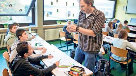 Eine Gruppe von Schülern - hier in einer Willkommensklasse für Flüchtlinge - im Gespräch mit ihrem Lehrer.