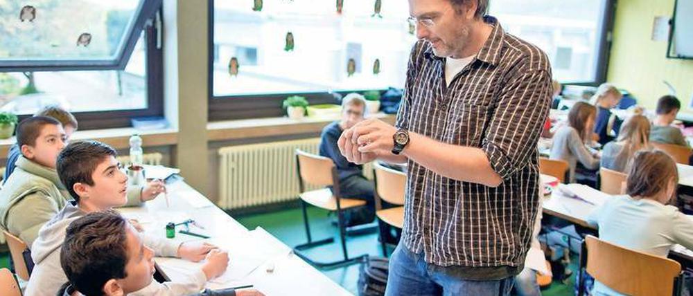 Eine Gruppe von Schülern - hier in einer Willkommensklasse für Flüchtlinge - im Gespräch mit ihrem Lehrer.