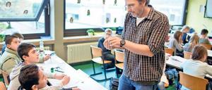 Eine Gruppe von Schülern - hier in einer Willkommensklasse für Flüchtlinge - im Gespräch mit ihrem Lehrer.