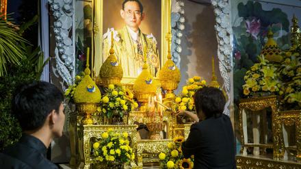 nTrauer, Gedenken und Erinnerung - eine Frau entzündet in einem buddhistischen Tempel in Bangkok eine Kerze für den verstorbenen König.