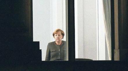 Die Bundeskanzlerin steht in der Nacht zum Freitag allein in der Nähe eines Fensters in der Parlamentarischen Gesellschaft. 