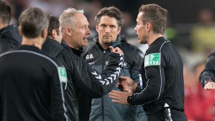 Christian Streich muss von Schiedsrichter Tobias Stieler beruhigt werden. Das klappte nur bedingt.