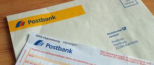 Girobriefumschlag und Überweisungsformular der Postbank. Mit den Umschlägen können Kunden ohne Internetanschluss bis Ende 2017 ihre Überweisungsaufträge oder Verrechnungsschecks gratis an das privatisierte Kreditinstitut schicken, das zum Konzern der Deutschen Bank gehört. Ab 2018 müssen sie dafür 0,70 Euro pro Umschlag zahlen, also das Briefporto.