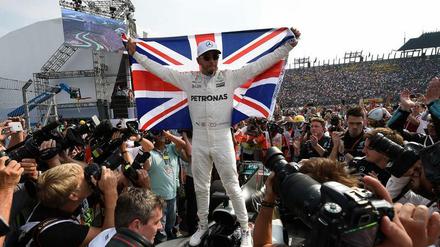 Ein Mann, eine Fahne. Lewis Hamilton feiert sich nach seinem WM-Titelgewinn.