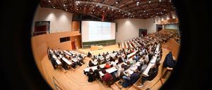Ein Professor steht in einem Hörsaal vor Studierenden.