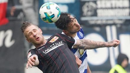 Der Duisburger Dustin Bomheuer (r) und der Berliner Sebastian Polter kämpfen um den Ball.