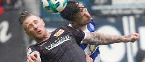 Der Duisburger Dustin Bomheuer (r) und der Berliner Sebastian Polter kämpfen um den Ball.