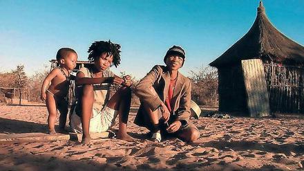 Wo die Familie in Frieden lebt. Vater, Mutter, Kind in der Kalahari-Wüste.