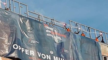 Unerlaubte Aktion. Mehrere Personen entrollten das Banner vom Dach des Hauses der Statistik und zündeten Bengalos.
