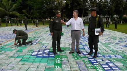 Der kolumbianische Präsident Juan Manuel Santos (M) und General Jorge Nieto (l) stehen auf einem großen Kokainfund. 