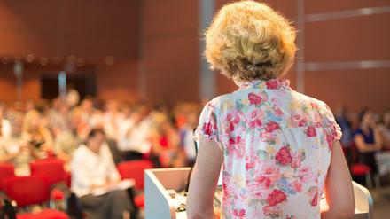 Eine Professorin steht am Pult vor einem Auditorium.