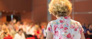 Eine Professorin steht am Pult vor einem Auditorium.