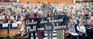 In einem Hörsaal wird ein Transparent mit dem Schriftzug "Unter den Talaren - Muff von 1000 Jahren" hochgehalten.