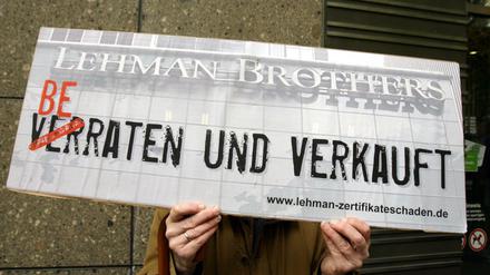 Ein Demonstrant hält 2008 in Düsseldorf ein Protestplakat in den Händen.