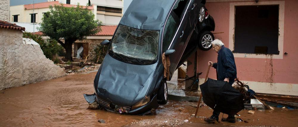 Durcheinandergewirbelt: Ein Mann geht am Mittwoch in Mandra an einem Auto vorbei, das gegen die Hauswand gedrückt wurde.