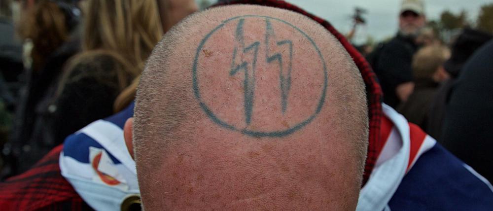 Manche stehen dazu. Ein Rechtsextremist aus den USA mit Kopf-Tatoo. Ähnliches trägt der Berliner Polizist am Körper.. 