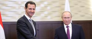 Der russische Präsident Wladimir Putin (r) und Syriens Präsident Baschar al-Assad (l) geben sich am Montag in Sotschi (Russland) die Hand.
