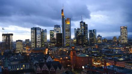 Die Altstadt mit Paulskirche (M) und Rathaus Römer in Frankfurt am Main (Hessen) bei Sonnenuntergang vor den erhellten Hochhäusern.