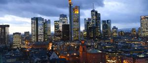 Die Altstadt mit Paulskirche (M) und Rathaus Römer in Frankfurt am Main (Hessen) bei Sonnenuntergang vor den erhellten Hochhäusern.