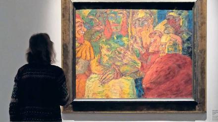 Eine Frau steht in einer Ausstellung vor einem Werk von Emil Nolde.