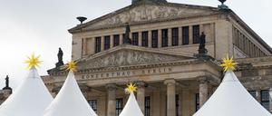 Es weihnachtet sehr auf dem Gendarmenmarkt. Die Zeltdächer vom Weihnachtsmarkt ragen vor dem Konzerthaus in den Himmel. 