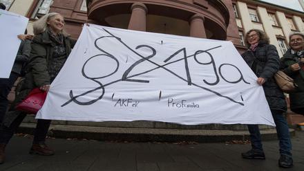 Mit einem Transparent fordern Demonstrantinnen am Freitag vor dem Amtsgericht in Gießen (Hessen) die Abschaffung des Paragrafen 219a.