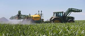 Ein Traktor mit Spruehanlage auf einem Maisfeld im Mansfelder Land (Sachsen-Anhalt)