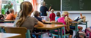Grundschulkinder sitzen in einem Klassenraum.