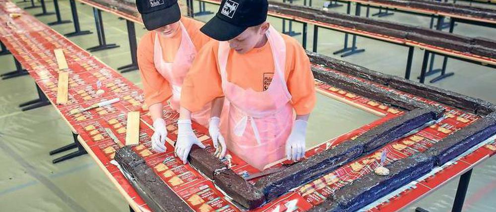 Schüler der Philipp-Reis-Schule setzen den Riesenkuchen zusammen.