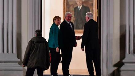 Bundespräsident Frank-Walter Steinmeier begrüßt am Donnerstagabend am Eingang von Schloss Bellewue Angela Merkel und Horst Seehofer. 