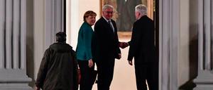 Bundespräsident Frank-Walter Steinmeier begrüßt am Donnerstagabend am Eingang von Schloss Bellewue Angela Merkel und Horst Seehofer. 