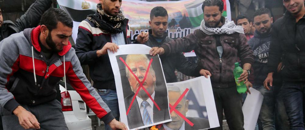 Palästinenser wollen in Rafah Poster verbrennen, auf denen US-Präsident Trump und Israels Ministerpräsident Netanjahu zu sehen sind.