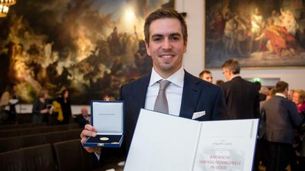Zu viel der Ehre: Ex-Profifußballer Philipp Lahm erhält die Bayerische Verfassungsmedaille im Landtag in München. Jetzt soll er Ehrenspielführer der Nationalmannschaft werden.