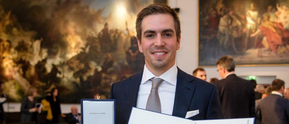 Zu viel der Ehre: Ex-Profifußballer Philipp Lahm erhält die Bayerische Verfassungsmedaille im Landtag in München. Jetzt soll er Ehrenspielführer der Nationalmannschaft werden.