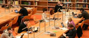 Forschende sitzen in der Staatsbibliothek vor ihren Laptops.