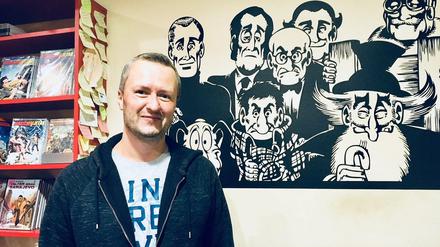 Almir Šehalić vor dem "Alan Ford"-Wandbild in seinem Comicbuchladen.