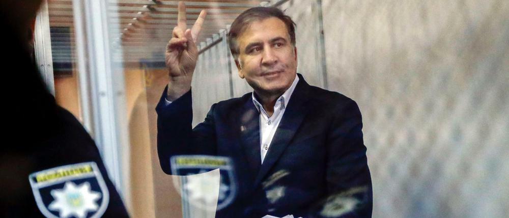 Der frühere Präsident Georgiens und jetzige ukrainische Oppositionelle Michail Saakaschwili zeigt in Kiew (Ukraine) im Gerichtssaal das Victory-Zeichen.