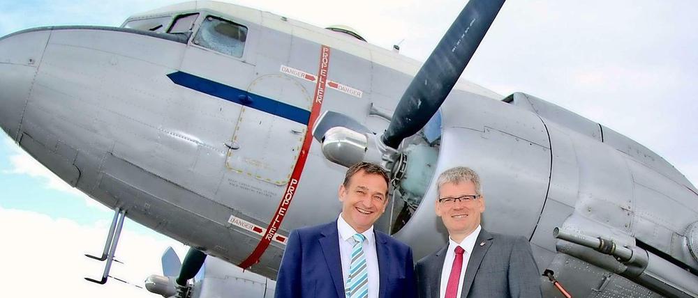 Die Bürgermeister Frank Bröhl (links) und Helmut Kleebank vor einem "Rosinenbomber" aus der Luftbrückenzeit.