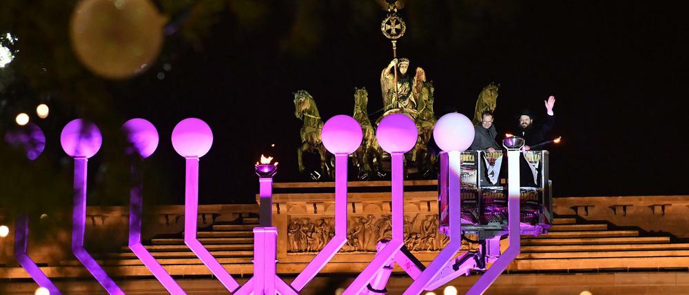 Licht im Dunkeln. Rabbiner Yehuda Teichtal (r) und Michael Müller zünden die erste Kerze am Chanukka-Leuchter vor dem Brandenburger Tor an.