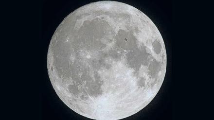 Mondsüchtig. Wem gehört der Mond? Und wer entscheidet, wie der Erdtrabant (im Vordergrund die ISS) genutzt werden darf? Mit den Erfolgen privater Raumfahrtunternehmen, die auch Rohstoffe abbauen wollen, stellen sich diese Fragen jetzt neu.