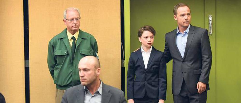 Stress. Opferschutzkommissar Carlos Benede (Matthias Koeberlin, rechts) begleitet Alexander (Joshio Marlon, Zweiter von rechts) zum Prozess, in dem er als Zeuge gegen seinen Vater (Ilir Rexhepi) aussagen wird. Der ermordete Alexanders Mutter. 