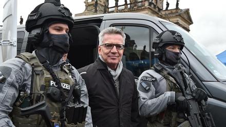 Bundesinnenminister Thomas de Maizière in Potsdam zwischen schwer bewaffneten Bundespolizisten.