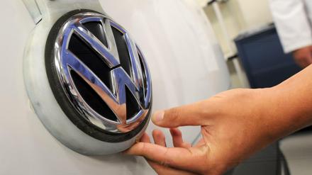 Ein Arbeiter im Volkswagen-Werk in Sao Bernardo do Compo nahe Sao Paulo, Brasilien, hält die Hand unter das VW-Logo .