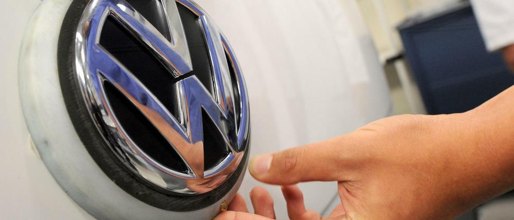 Ein Arbeiter im Volkswagen-Werk in Sao Bernardo do Compo nahe Sao Paulo, Brasilien, hält die Hand unter das VW-Logo .