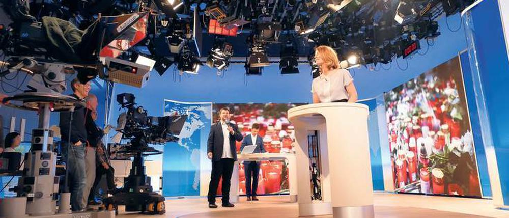 Stellprobe unterm Scheinwerfer-Himmel. „Mittagsmagazin“-Regisseur Thomas Neuner (mit Mikrofon) gibt bei den Proben den Moderatoren Jessy Wellmer und Sascha Hingst letzte Anweisungen.
