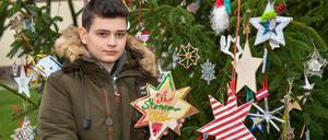 Timo zeigt Sterne aus verschiedenen Ländern am Weihnachtsbaum im heimischen Beeskow. 