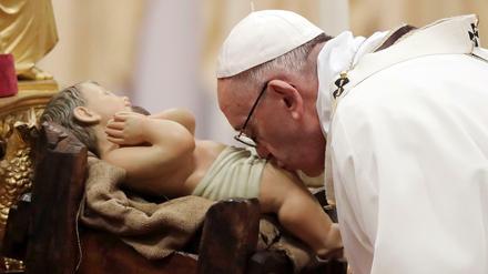 Papst Franziskus küsst am 24.12.2017 bei der Weihnachtsmesse im Petersdom im Vatikan das Christuskind.