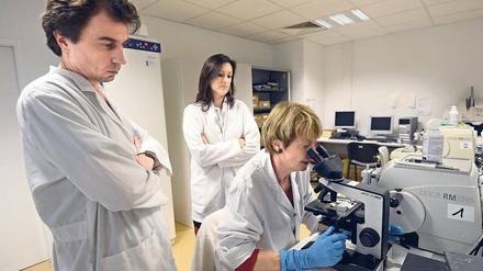 Drei am Mikroskop. Am wenigsten Zweifel an der Diagnose und an der Therapieempfehlung des behandelnden Arztes kommen bei den Patienten auf, wenn sie „regelhaft interdisziplinär und auf höchstem fachlichen Niveau getroffen werden“. Foto: Anne-Christine Poujoulat/AFP