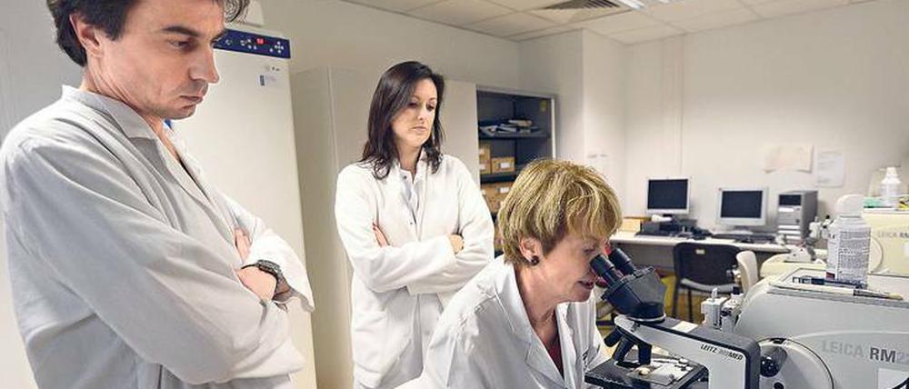 Drei am Mikroskop. Am wenigsten Zweifel an der Diagnose und an der Therapieempfehlung des behandelnden Arztes kommen bei den Patienten auf, wenn sie „regelhaft interdisziplinär und auf höchstem fachlichen Niveau getroffen werden“. Foto: Anne-Christine Poujoulat/AFP