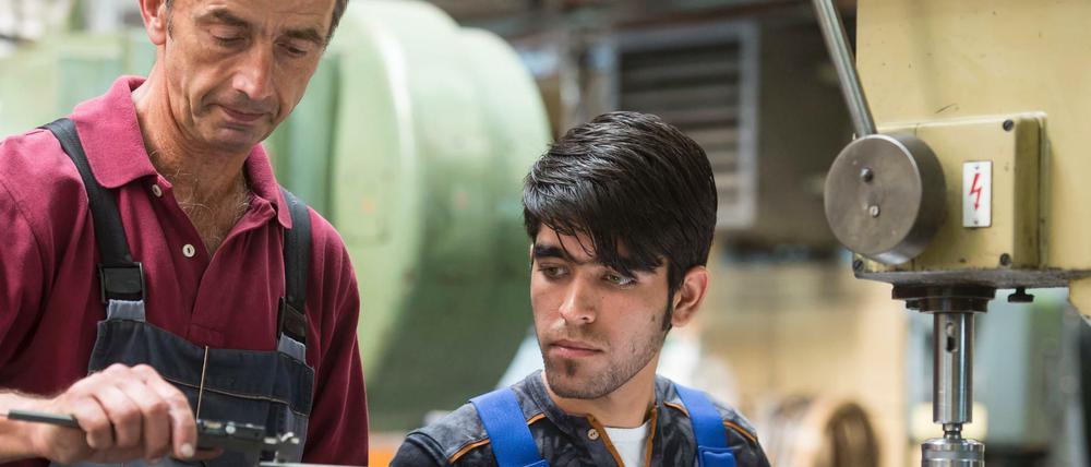 Ausbilder Wolfgang Wonneberger (l) von der Jenaer Feinblech GmbH in Jena (Thüringen) mit dem 19-jährigen Flüchtling Rezwan Waziri aus Afghanistan.